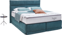 Boxspringbett in türkisem Stoff mit Volant und Nähte im Kopfhaupt