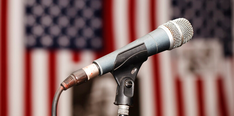 US-flag-with-microphone-in-foreground