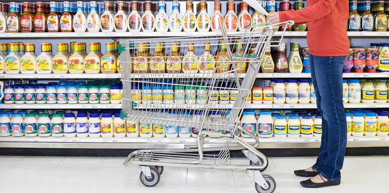Shopper-checking-list-in-supermarket-aisle