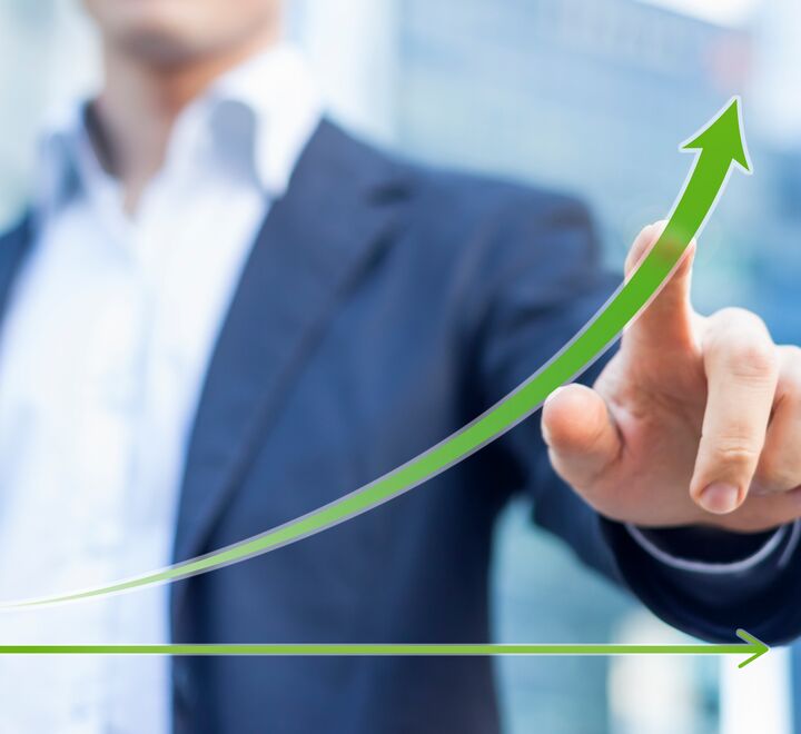 Bilde av en mann som peker på en stigende grønn graf