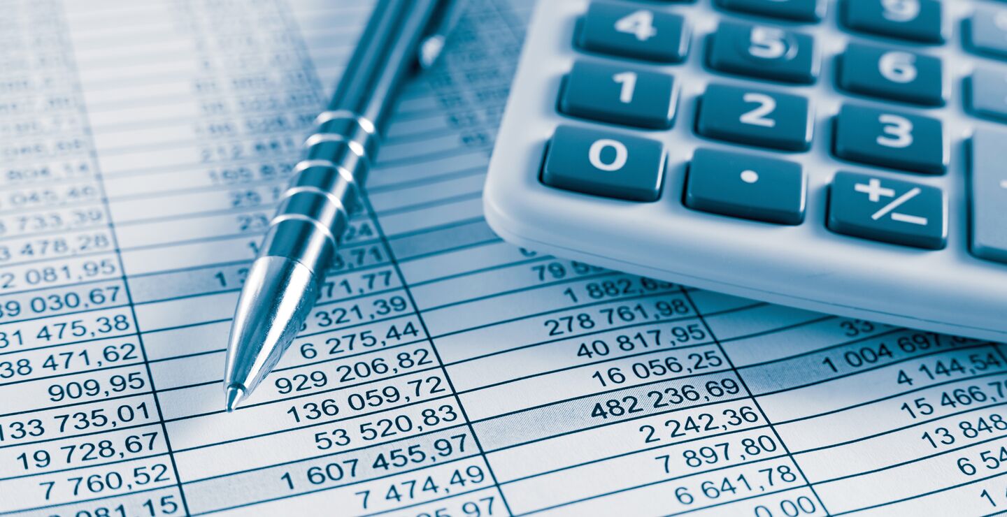 En kalkulator og en penn som ligger på excel ark