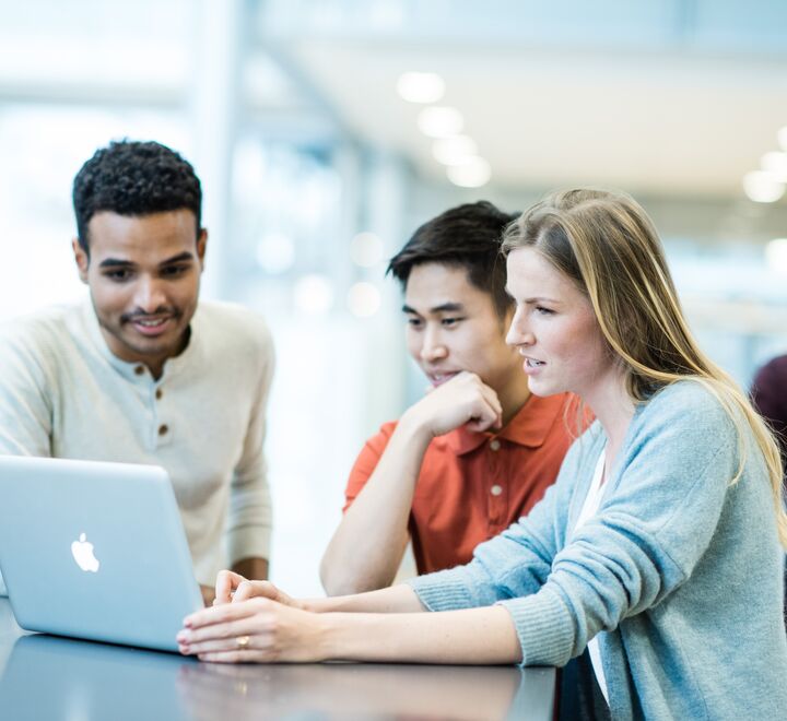 Students pointing towards a computer