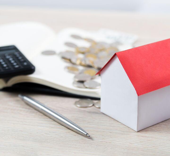 Small house next to coins and a calculator