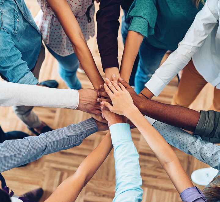 En gruppe mennesker samler hender