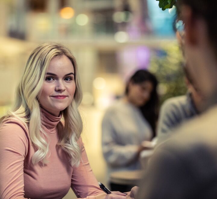 Bilde av ei blond kvinne på campus
