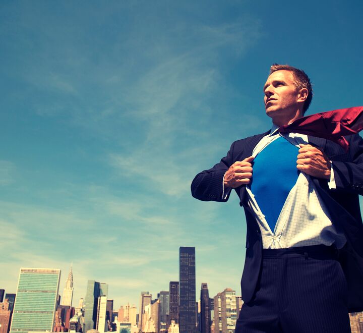 Leader poses with a super hero suit underneat the clothes