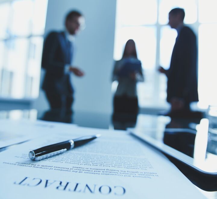 Three office workers with a contract