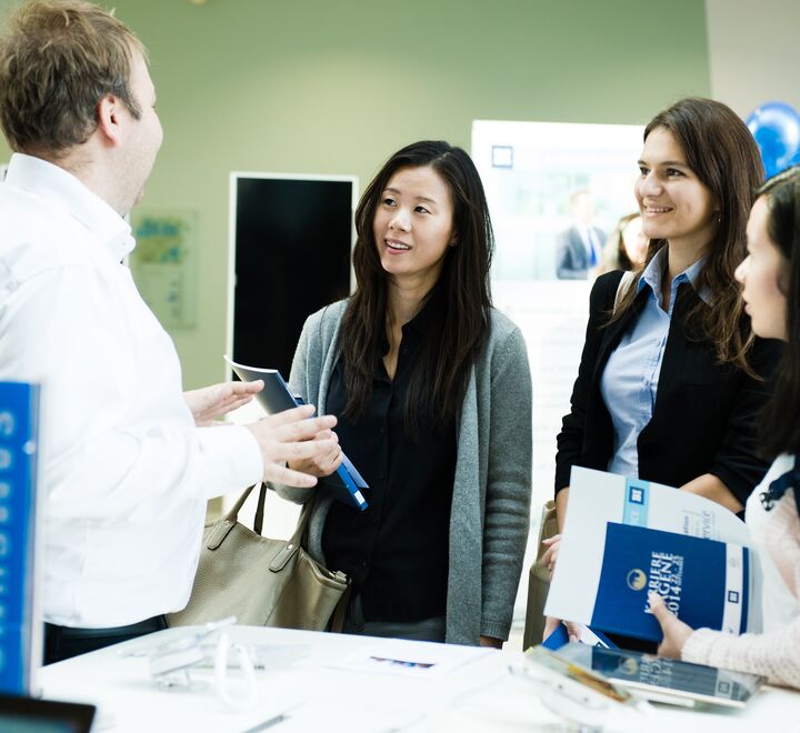 Students talking to a man at a stand during Karrieredagene