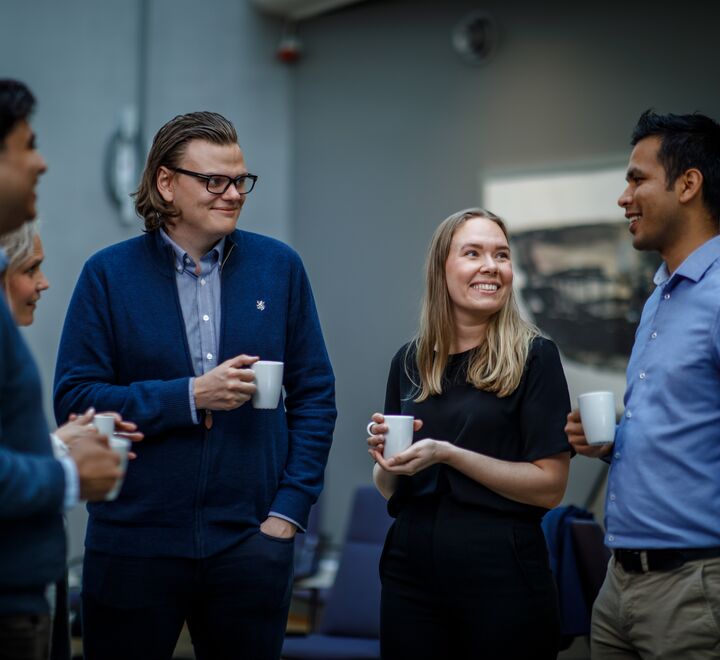 Group of people talking and drinking coffee.