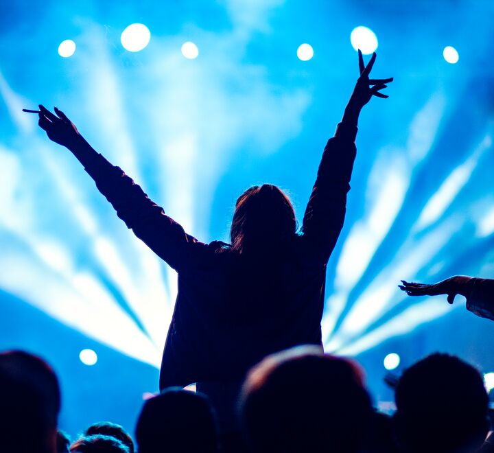 Person på konsert med armene over hodet