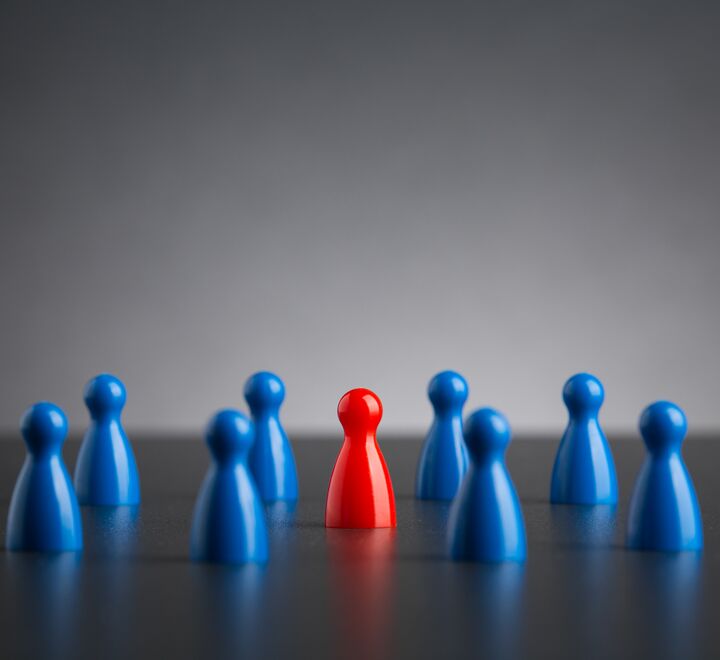 Illustrasjon av gruppepress der blå spillebrikker omringer en rød spillebrikk