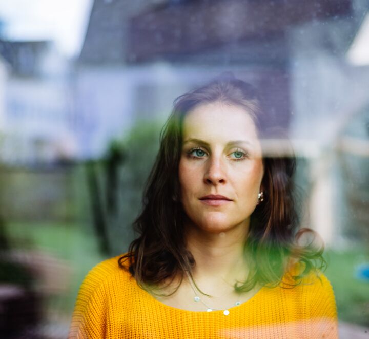 Woman looks thoughtfully through the window.