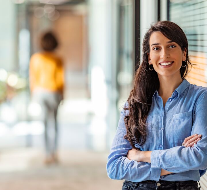 Smilende dame som lener seg inntil en vegg