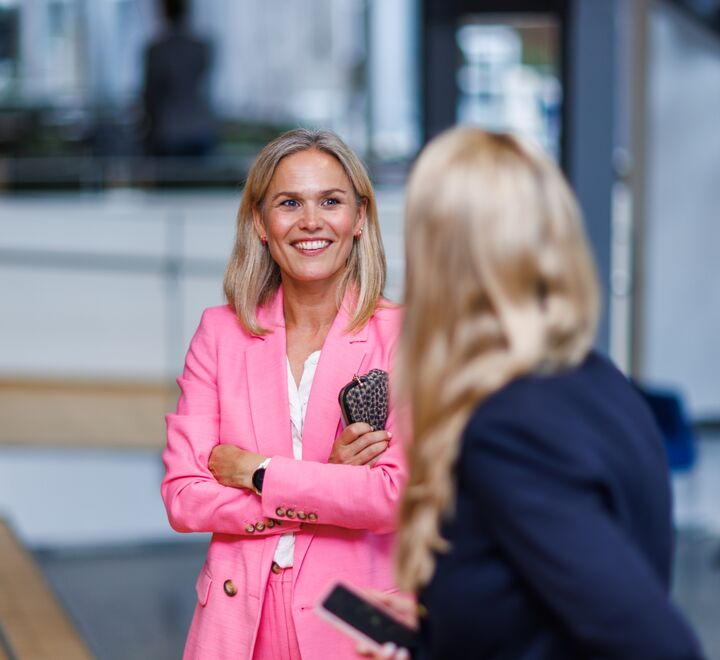 Dame i rosa blazer som mingler under Alumnidagen 2023