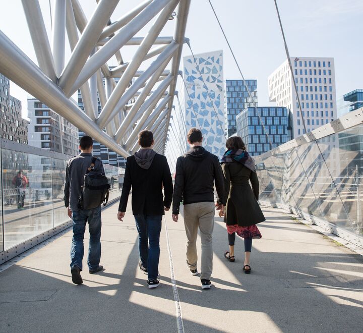 A group of people walking towards Barcode in Oslo