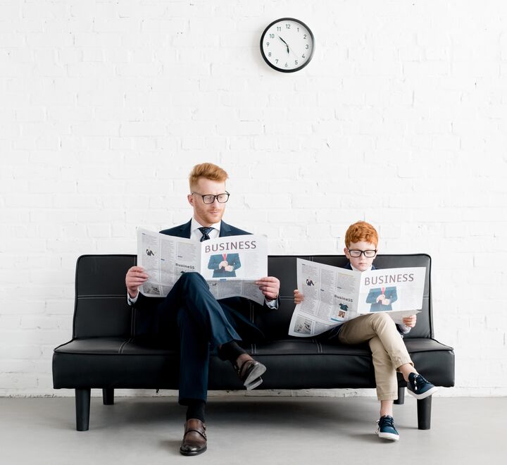 Father and son reading a news paper