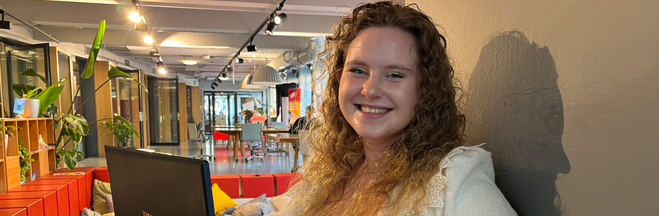 Elena met laptop in Amsterdam Law Hub