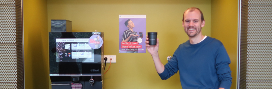 Japser Bok holding an UvA coffee cup