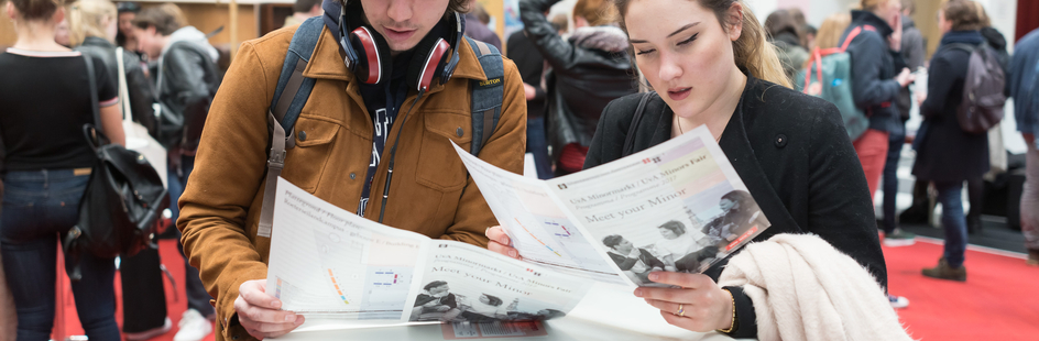 Two students look at a brochure during the UvA Minors Fair.