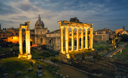 View of the temple of Saturn in Roman forum at night, Italy. Ruins of Septimius Severus Arch and Saturn Temple. Rome architecture and landmark.