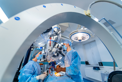 Group of neurosurgeons in operating room with surgery equipment. Doctors using hi-tech equipment. Modern medical background.
