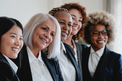 Multiracial business women having fun inside modern office - Focus on left senior female
