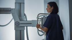 Hospital Radiology Room: Female Latin Nurse Adjusts X-Ray Machine. Healthy Patient Undergoes Medical Exam Scanning with the Doctor's Help. Side View Shot.; Shutterstock ID 1942278178; purchase_order: Bynder Library; job: ; client: ; other: