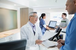 Doctor discussing paperwork with patient in clinic