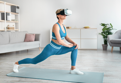 VR Workout App, Fitness Game. Sporty lady in vrtual reality headset exercising using digital application, making forward lunges at home. Woman using modern technologies for online domestic training