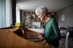 一个ctive senior woman concentrating while working on laptop