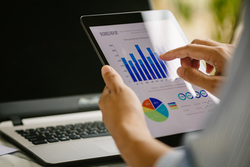Digital marketing, businessman using smart tablet and documents on office desk background. Concept for business strategy, economy and tax.