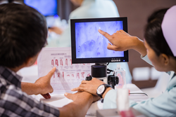 Nurses with fingerprint technology to patient.