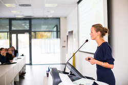 Young business woman giving a presentation in a conference/meeting setting (shallow DOF; color toned image)
