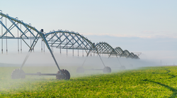 Moved irrigation system on a farmer's field. Field irrigation with a pivot sprinkler system.  Watering plants with spray technology. Yield increase.