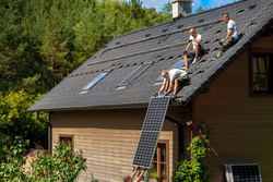 Men worker installing solar photovoltaic panels on roof, alternative energy, saving resources and sustainable lifestyle concept.
